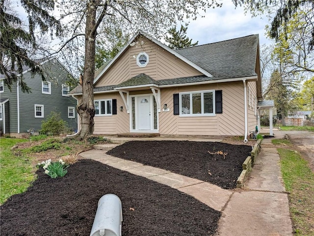 bungalow-style home with a shingled roof