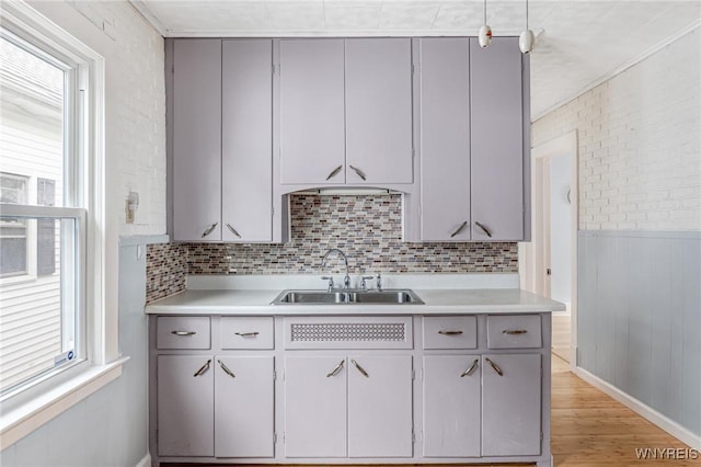 kitchen with plenty of natural light, a sink, light wood-style floors, and light countertops