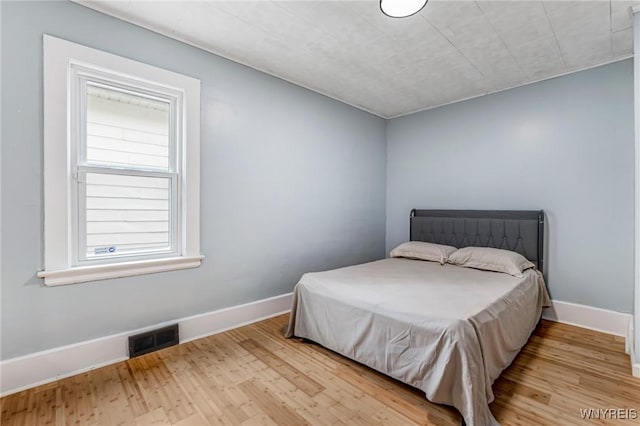 bedroom featuring visible vents, wood finished floors, and baseboards