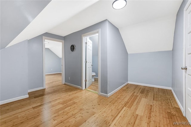 bonus room with baseboards, wood finished floors, and lofted ceiling