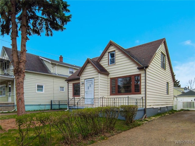 bungalow-style house featuring roof with shingles, crawl space, and fence