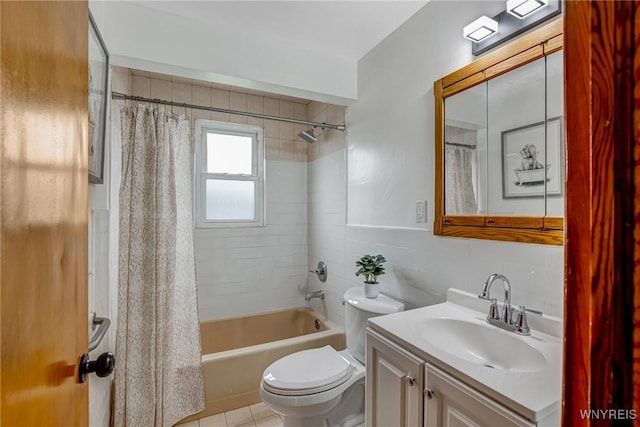 full bath with tile patterned flooring, tile walls, shower / bath combo, toilet, and vanity