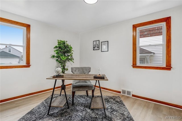 office with baseboards, visible vents, and light wood-style flooring