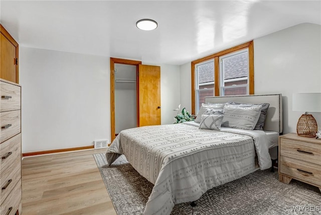 bedroom featuring a closet, visible vents, baseboards, and light wood-type flooring