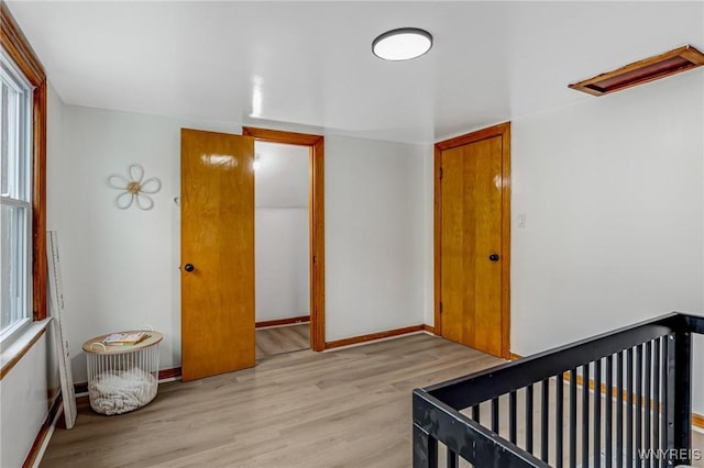 bedroom featuring light wood finished floors and baseboards