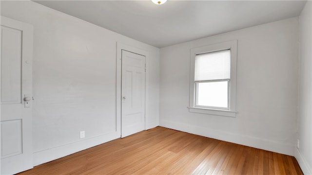 unfurnished bedroom with baseboards, a closet, and light wood finished floors