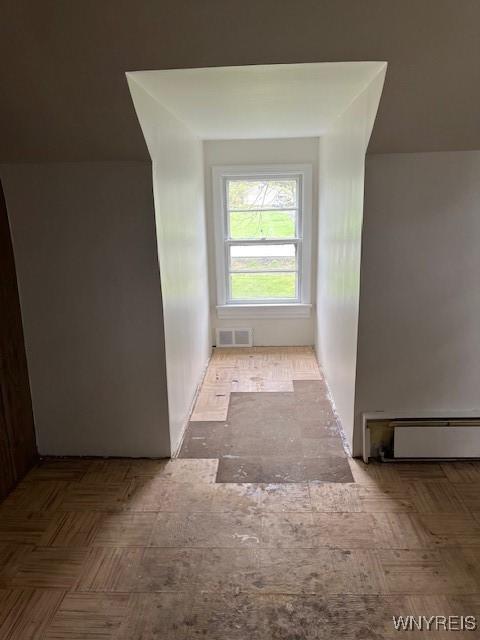 additional living space featuring visible vents and a baseboard radiator