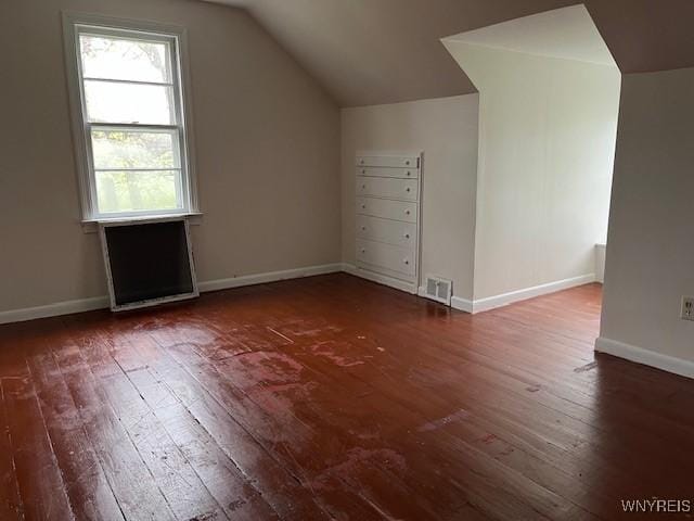 additional living space featuring lofted ceiling, hardwood / wood-style flooring, and baseboards