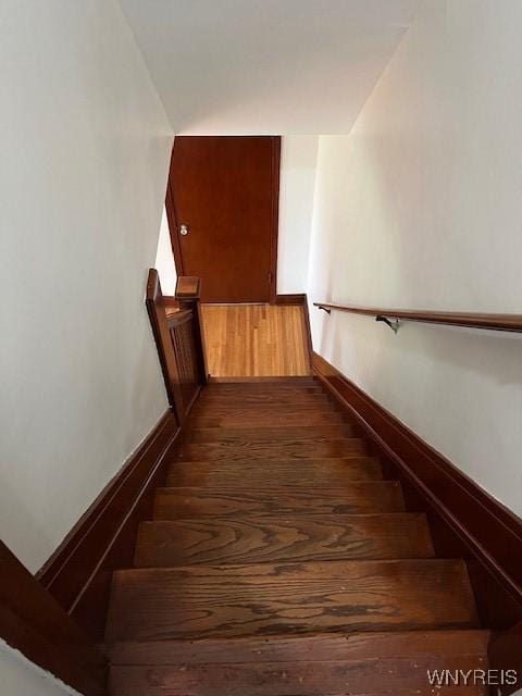 stairs featuring wood finished floors