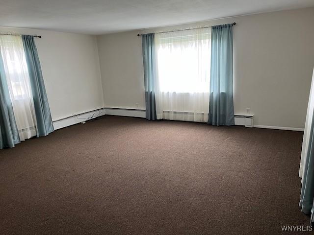 spare room with a baseboard heating unit and carpet floors