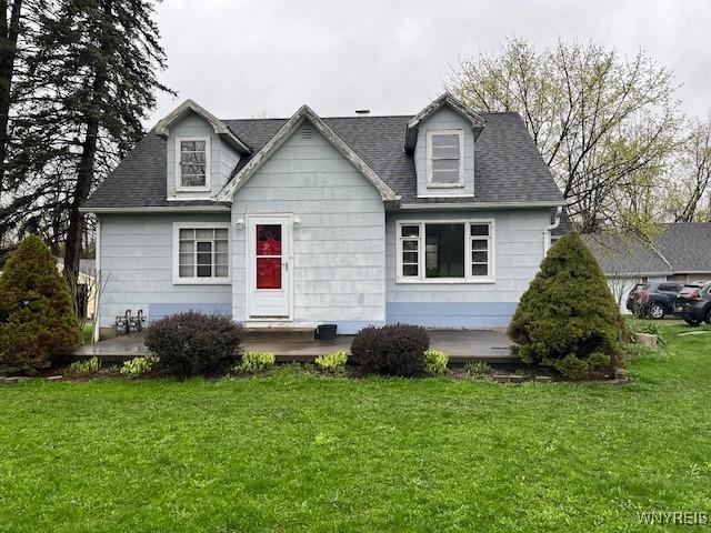 view of front of property with a shingled roof and a front lawn