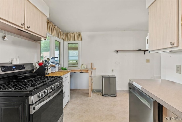 kitchen with light brown cabinetry, light floors, appliances with stainless steel finishes, and light countertops