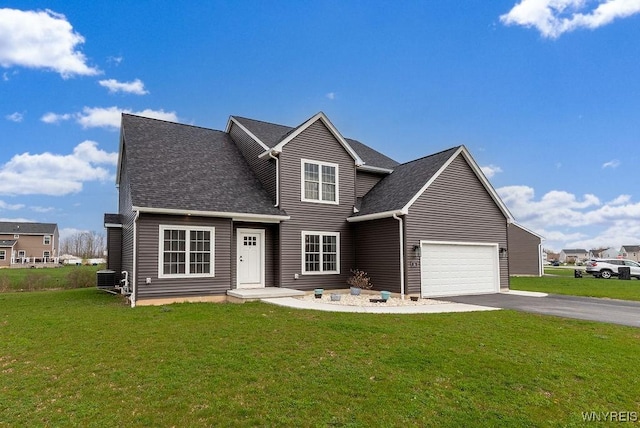 traditional-style home with central air condition unit, aphalt driveway, a shingled roof, and a front lawn