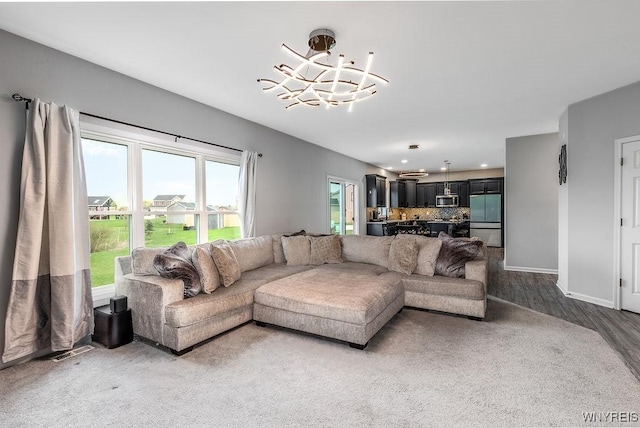 living area with recessed lighting, wood finished floors, baseboards, visible vents, and a notable chandelier