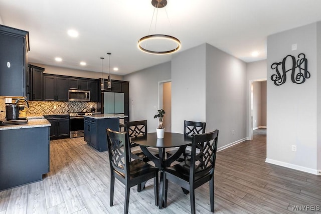 dining area featuring baseboards, recessed lighting, and light wood-style floors