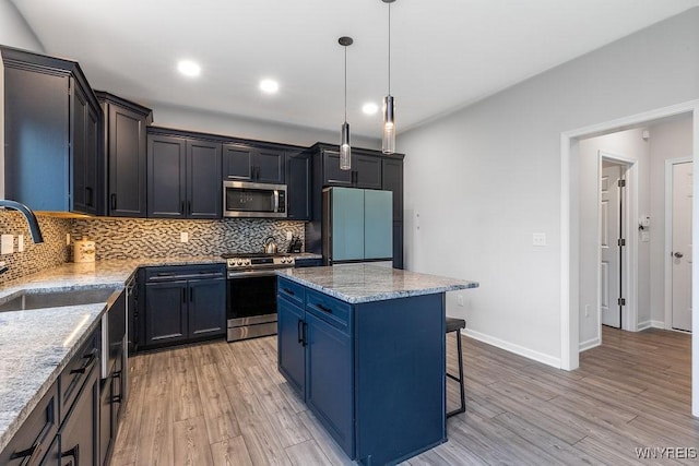 kitchen featuring a breakfast bar area, tasteful backsplash, light wood-type flooring, and appliances with stainless steel finishes