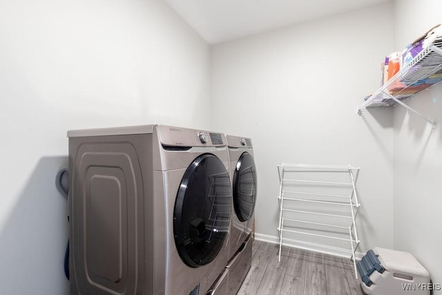 laundry room with baseboards, wood finished floors, laundry area, and independent washer and dryer