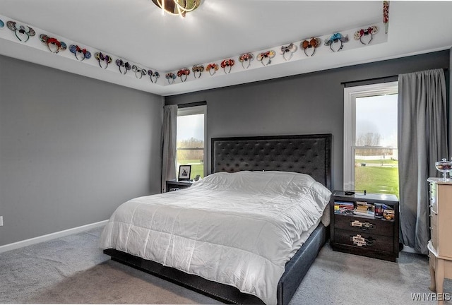 carpeted bedroom with multiple windows and baseboards