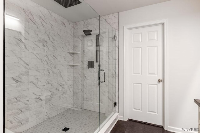 bathroom with baseboards, a stall shower, and tile patterned flooring