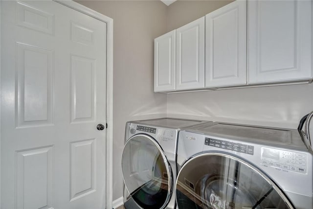 washroom featuring cabinet space and washing machine and dryer