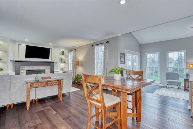 dining space with recessed lighting, dark wood-style flooring, lofted ceiling, and a fireplace
