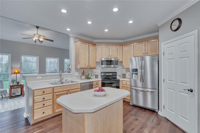 kitchen featuring light brown cabinetry, appliances with stainless steel finishes, crown molding, and a sink