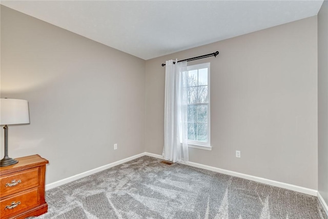 unfurnished room featuring visible vents, carpet floors, and baseboards