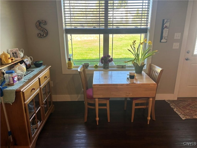 dining area with baseboards and dark wood finished floors
