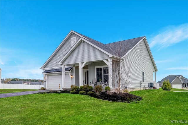view of front facade featuring a front yard, fence, cooling unit, aphalt driveway, and an attached garage