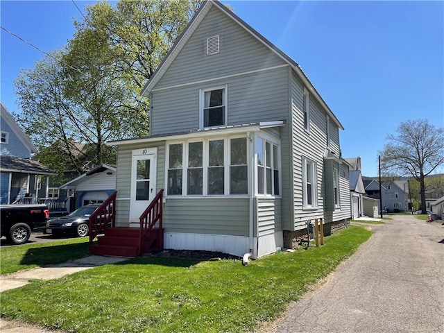 view of front of home featuring aphalt driveway, a front yard, and entry steps