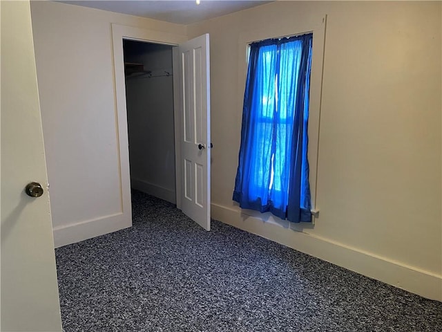 unfurnished bedroom featuring baseboards and a closet