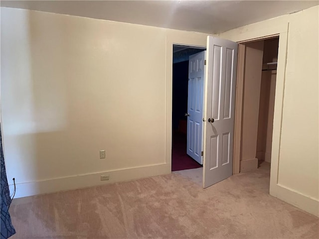 unfurnished bedroom with light colored carpet and baseboards
