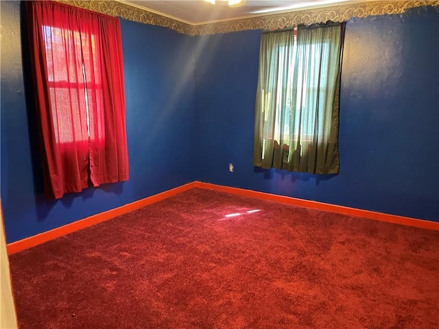 spare room featuring baseboards, a healthy amount of sunlight, and carpet flooring