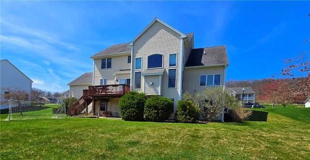 rear view of property with a lawn, fence, stairs, and a wooden deck