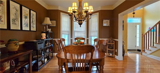 dining room with baseboards, wood finished floors, a notable chandelier, and stairs