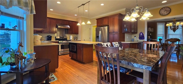 kitchen featuring light wood-style flooring, under cabinet range hood, appliances with stainless steel finishes, light countertops, and a notable chandelier