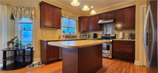 kitchen featuring light wood-style flooring, appliances with stainless steel finishes, under cabinet range hood, light countertops, and a center island