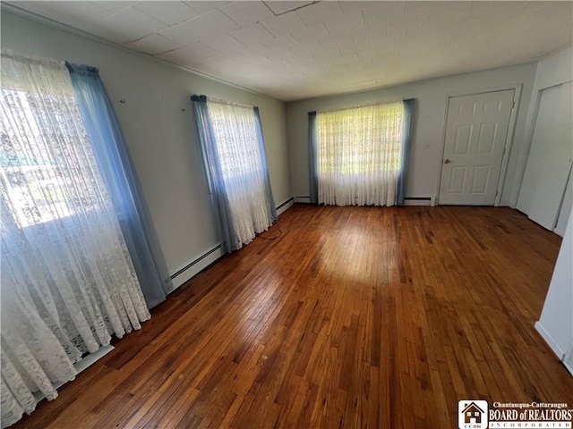 empty room with baseboard heating and wood-type flooring