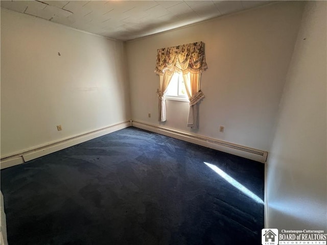 spare room with dark carpet, baseboard heating, and baseboards