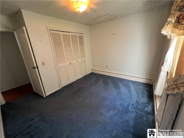 unfurnished bedroom with a closet, dark colored carpet, and baseboards