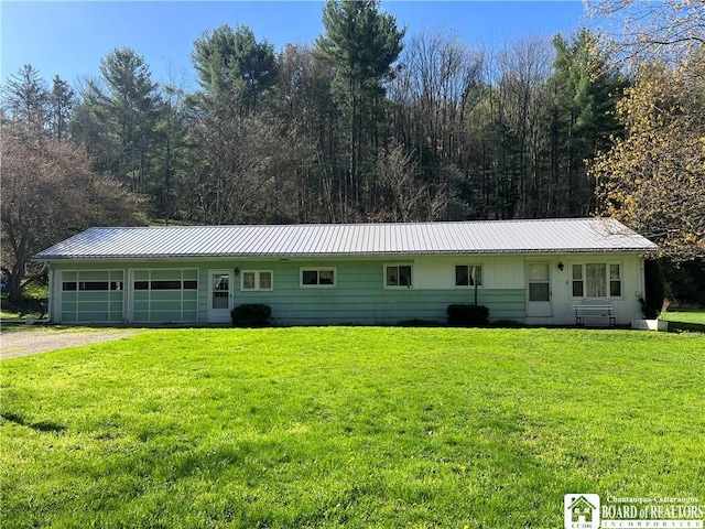single story home with driveway, a front yard, and metal roof