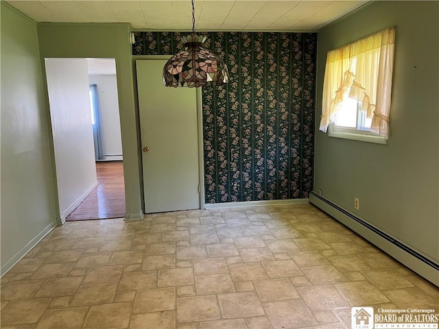 unfurnished dining area with stone finish flooring, a baseboard heating unit, and baseboards