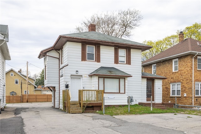 view of front of property with a chimney and fence
