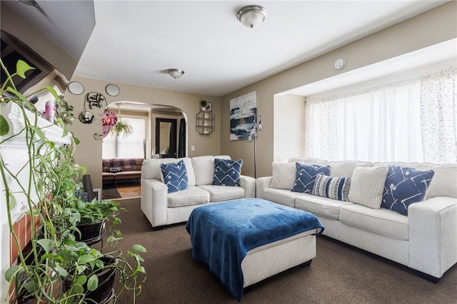 carpeted living room with arched walkways