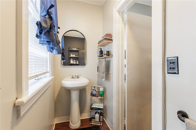 bathroom with a sink, wood finished floors, and baseboards