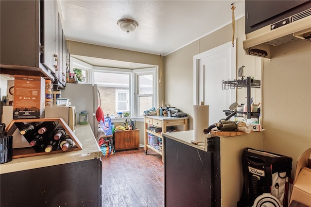 kitchen with light countertops, hardwood / wood-style flooring, and under cabinet range hood