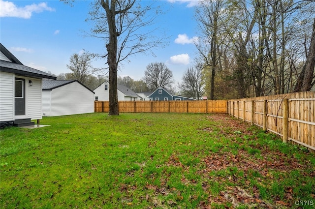 view of yard featuring entry steps and a fenced backyard