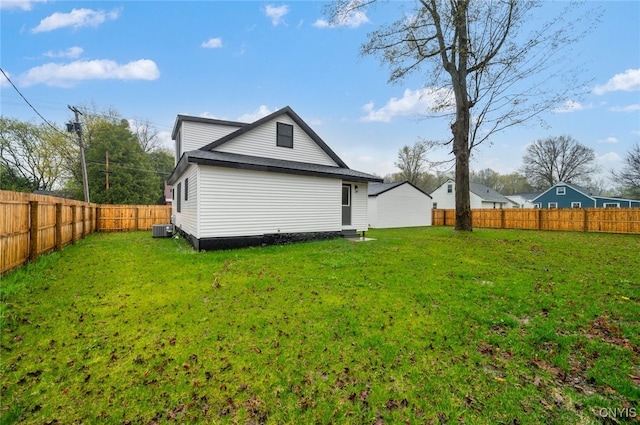 rear view of property featuring cooling unit, a yard, and a fenced backyard