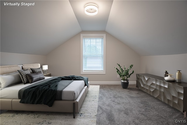 carpeted bedroom with lofted ceiling and baseboards