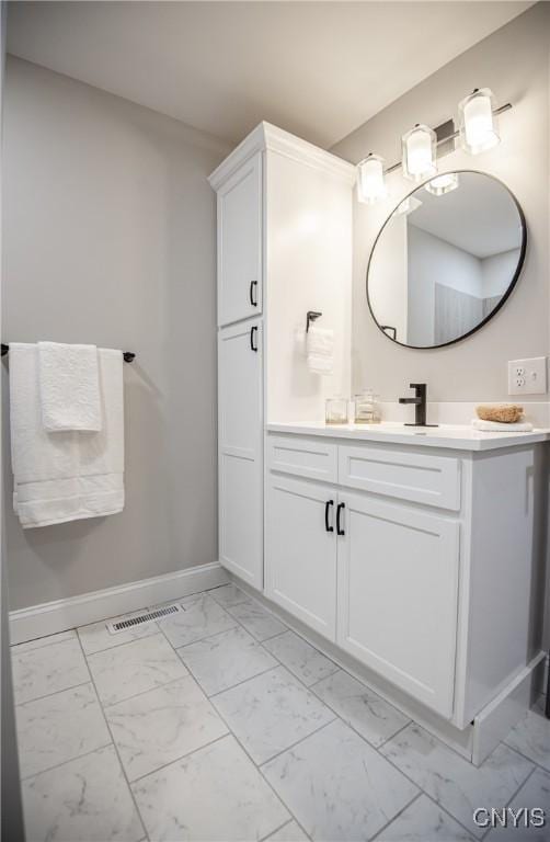 bathroom featuring baseboards, visible vents, vanity, and marble finish floor